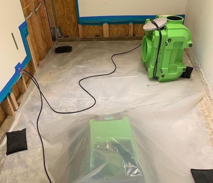 Air scrubbers and sandbags on polyethylene sheet in a room with sealed flood cuts