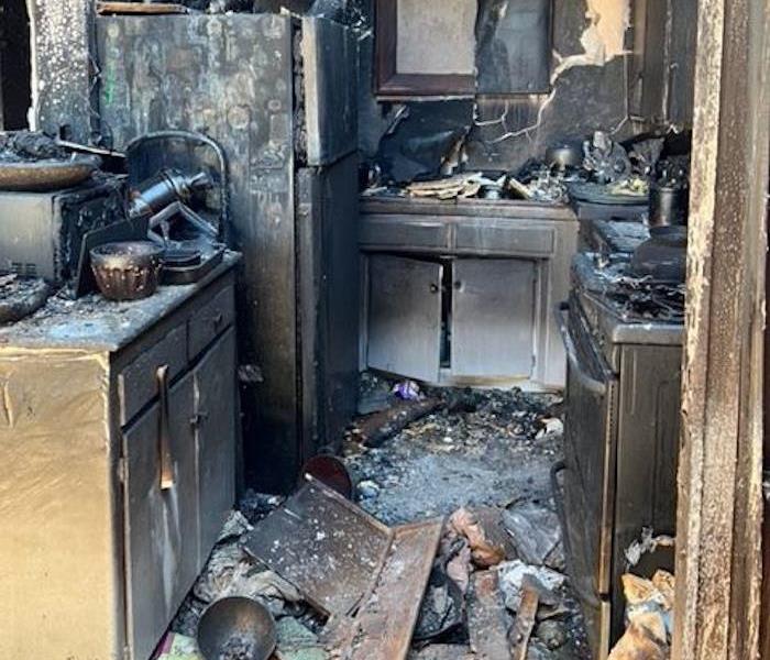 A severely fire-damaged kitchen.