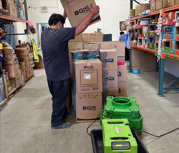 SERVPRO air scrubbers and drying equipment operating in a commercial warehouse space