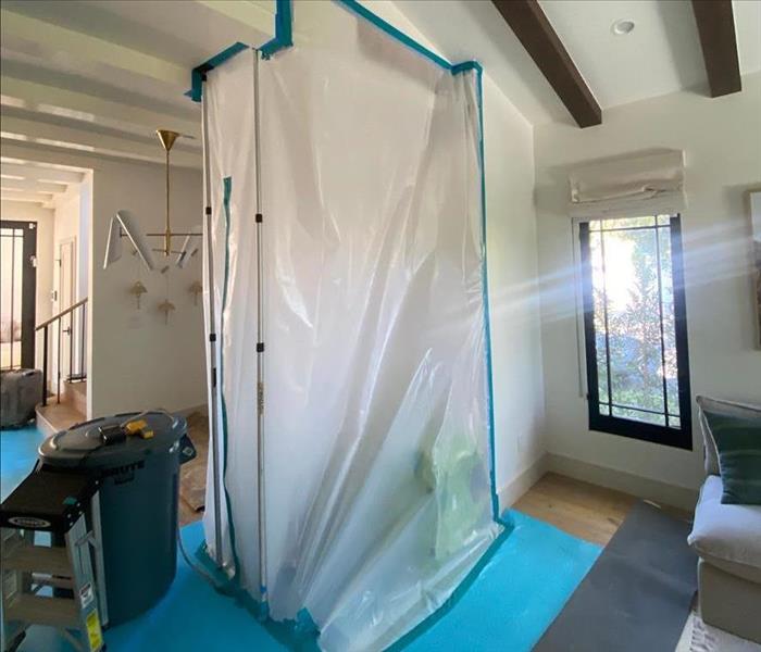 Sealed polyethylene chamber in a living room with SERVPRO drying equipment
