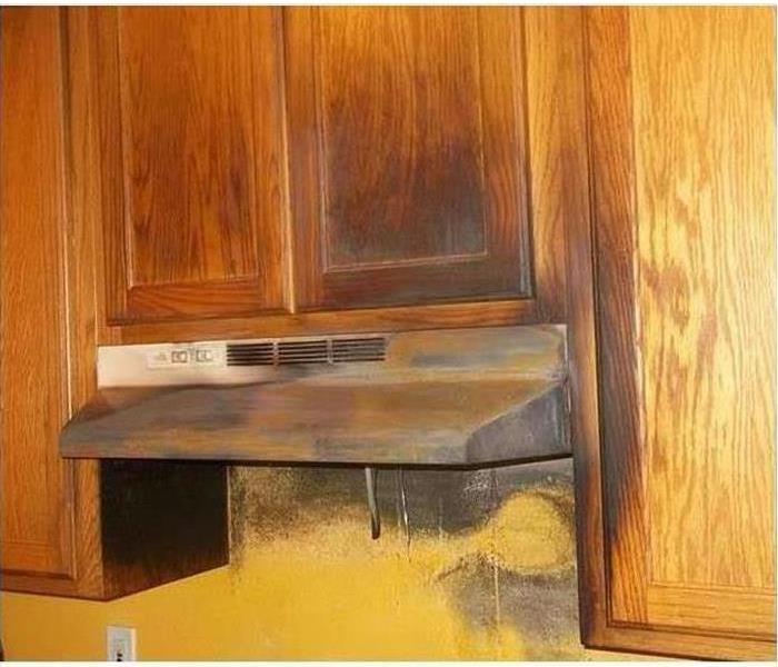 kitchen cabinets and vent hood covered in soot after fire damage